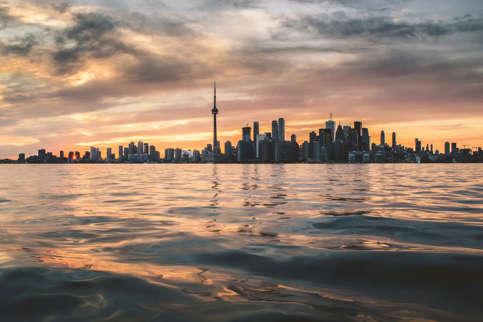 The Toronto skyline and CN Tower across Lake Ontario at dusk